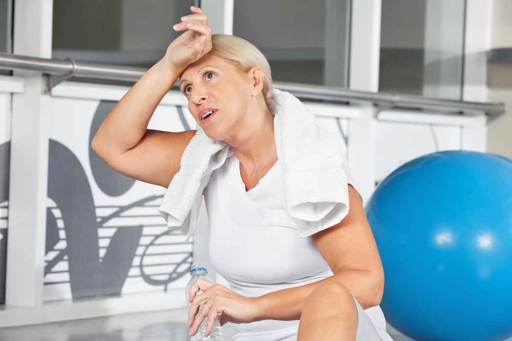 Mujer en meopausia sudando en el gym